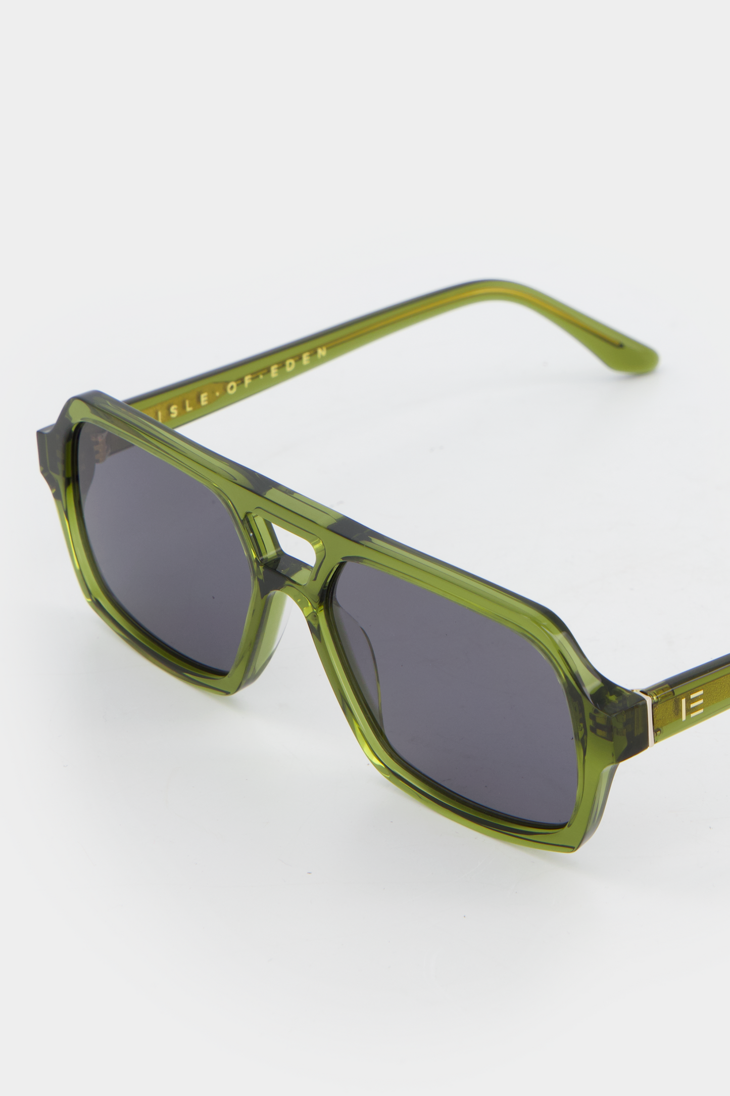 Close-up of Isle of Eden Lola bottle green sunglasses showing aviator frame and brand lettering