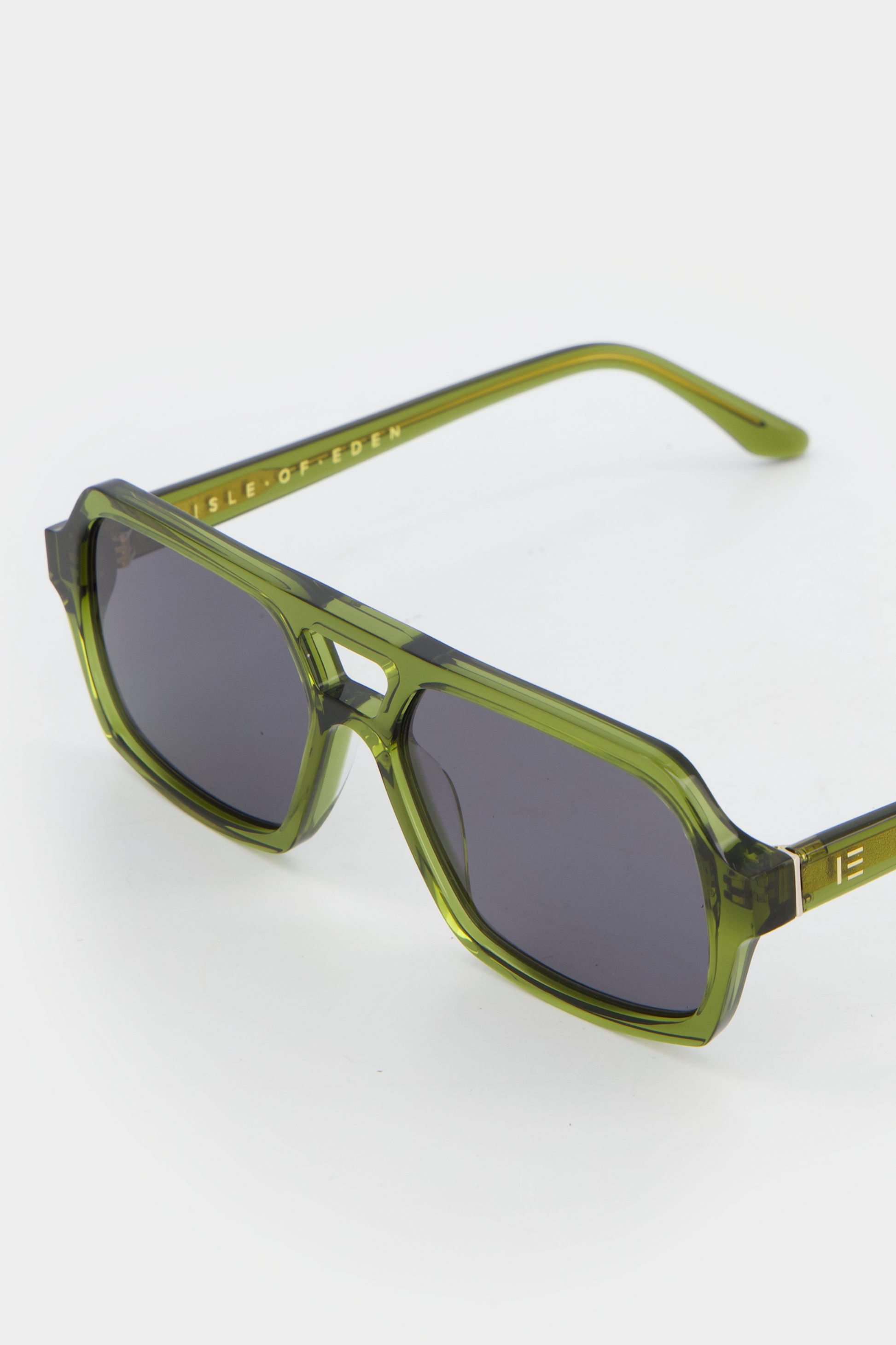 Close-up of Isle of Eden Lola bottle green sunglasses showing aviator frame and brand lettering