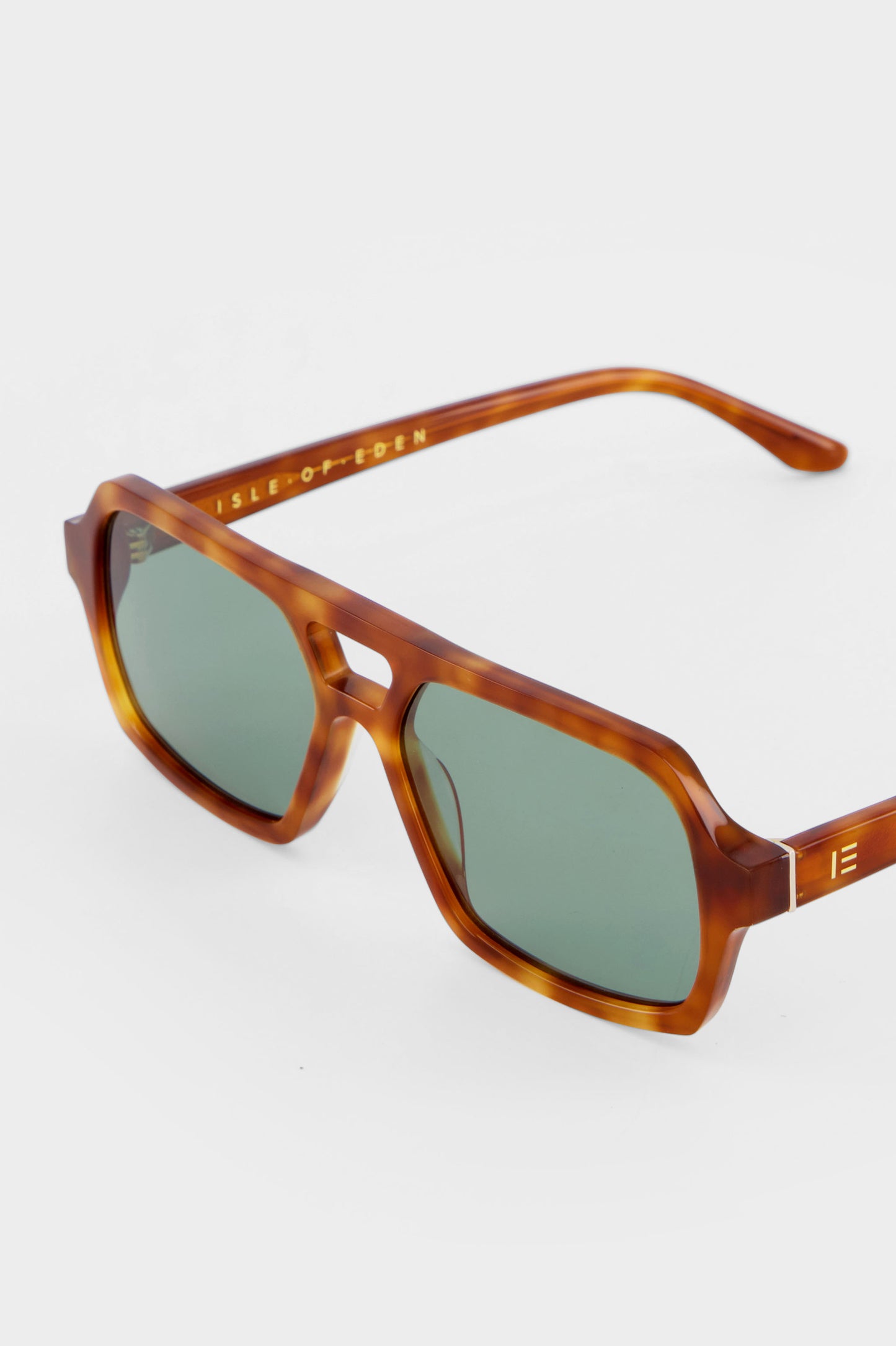 Close-up of Isle of Eden Lola honey tortoise sunglasses showing aviator frame and brand lettering