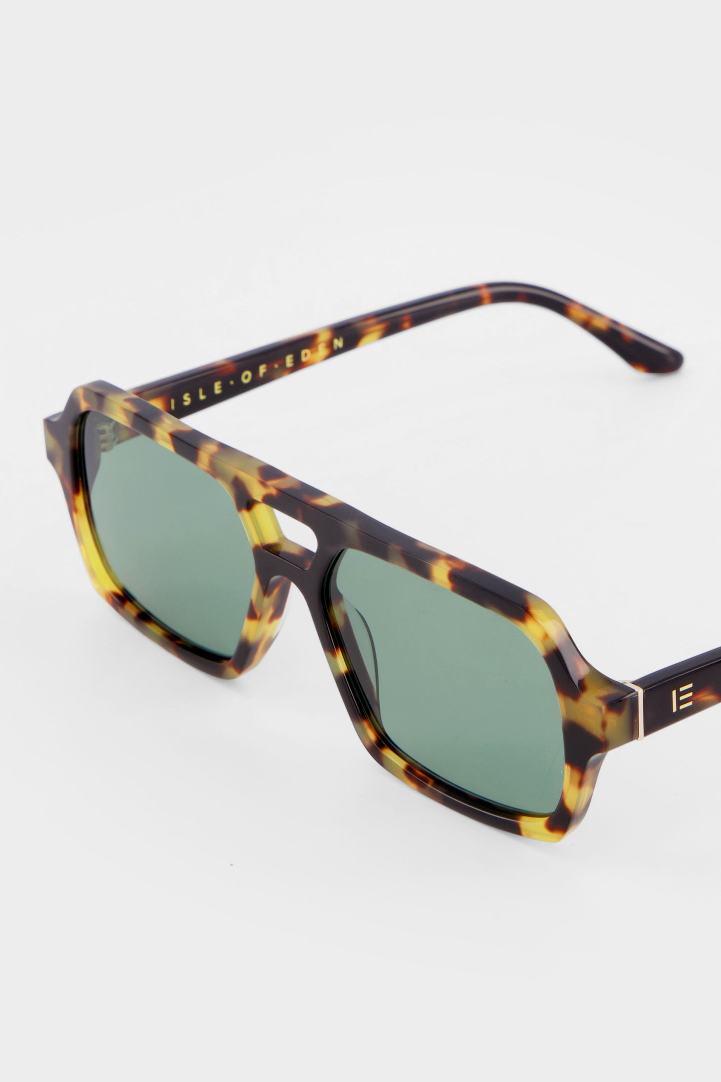 Close-up of Isle of Eden Lola tortoise sunglasses showing aviator frame and brand lettering