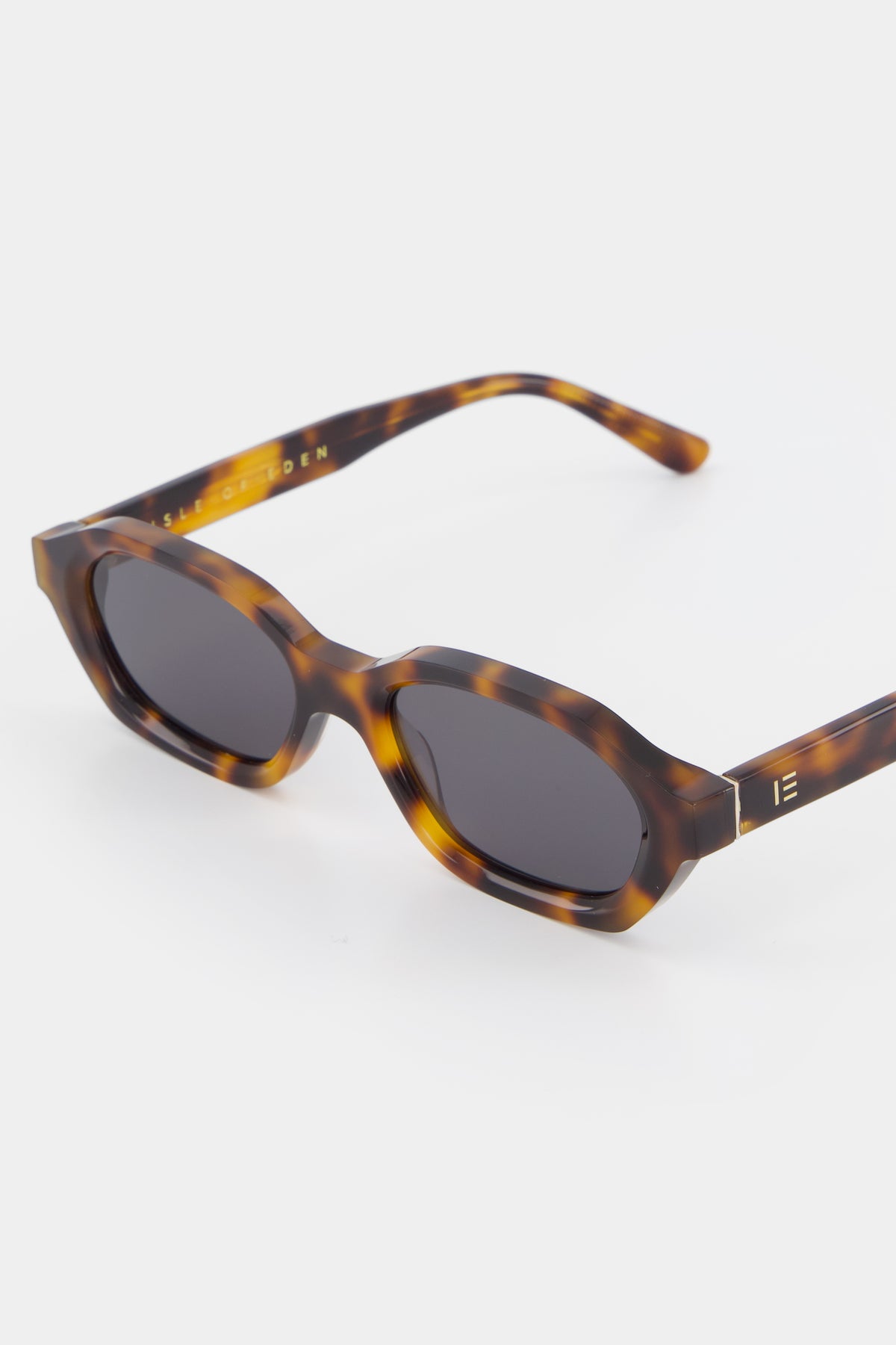 Close-up of Isle of Eden Luca tortoise sunglasses showing hexagonal frame and brand lettering