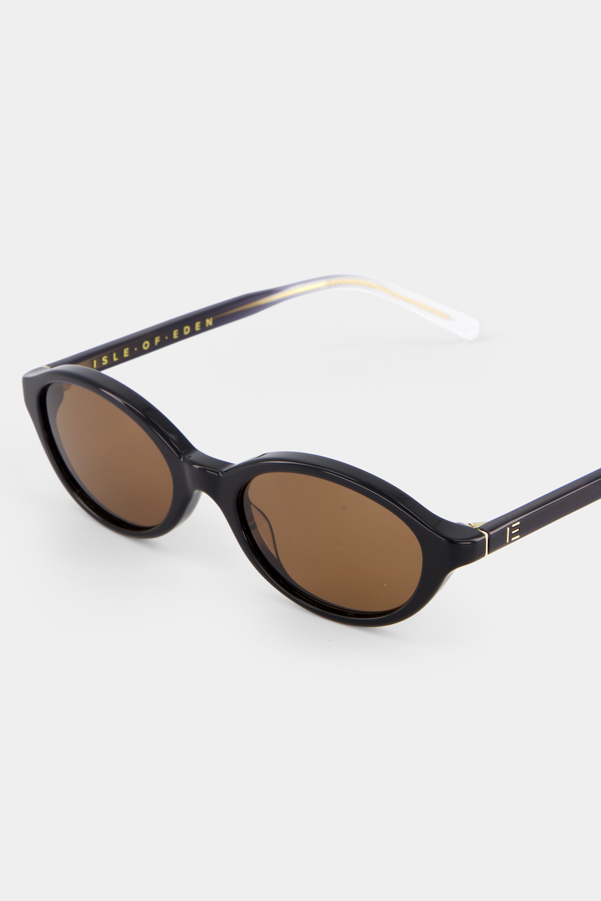Close-up of Isle of Eden Mirabel black sunglasses showing sleek oval frame and brand lettering