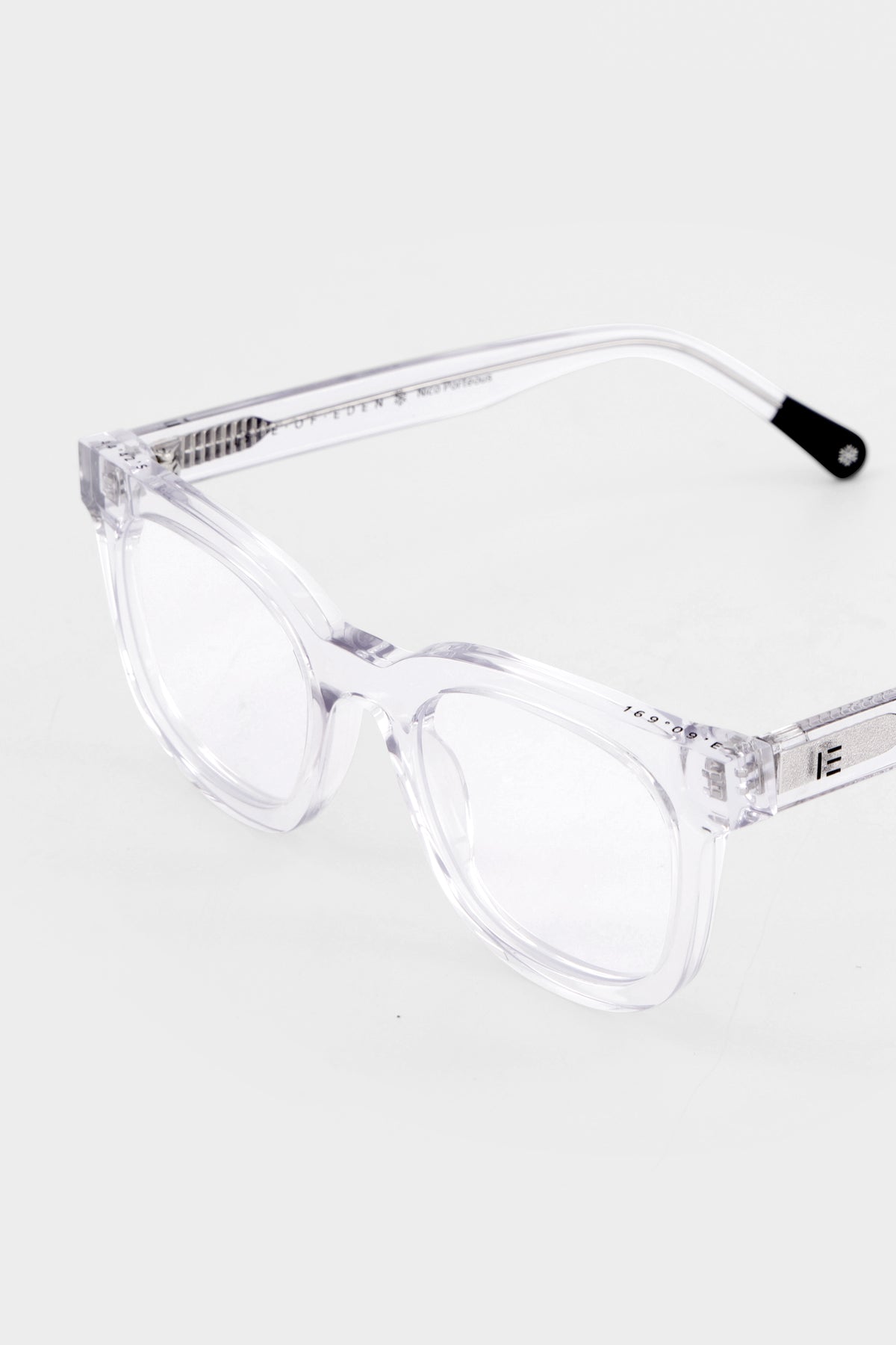 Close-up of Isle of Eden Nico Blue Light eyeglasses showing flat brow square frame and brand lettering