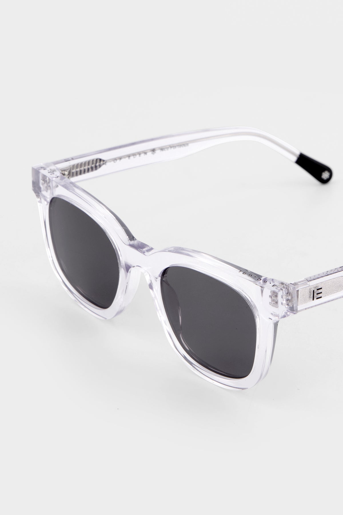 Close-up of Isle of Eden Nico Sun crystal sunglasses showing flat brow square frame and brand lettering