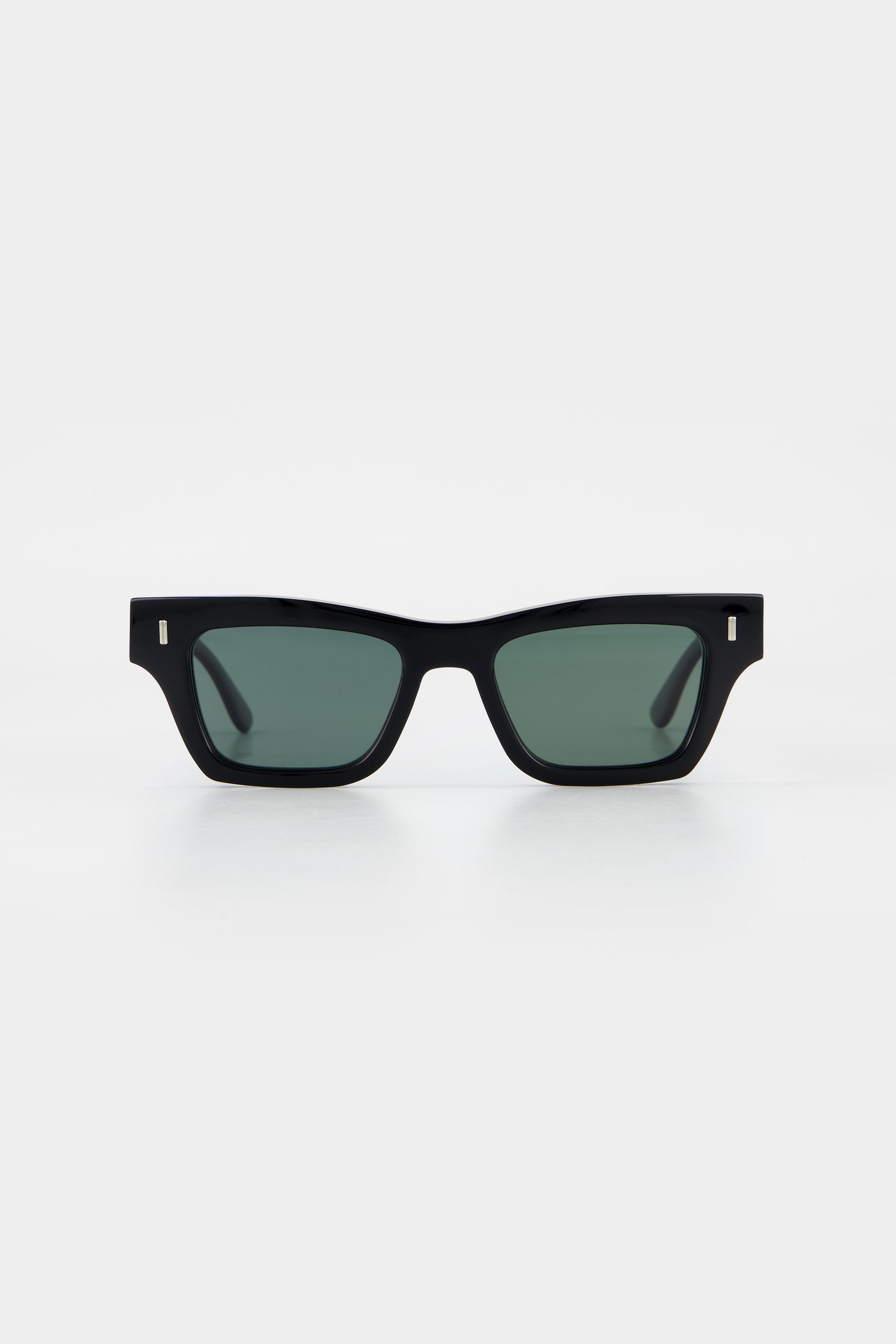 Isle of Eden Olli black sunglasses, front view showing low-profile art-deco frame and dark green lenses