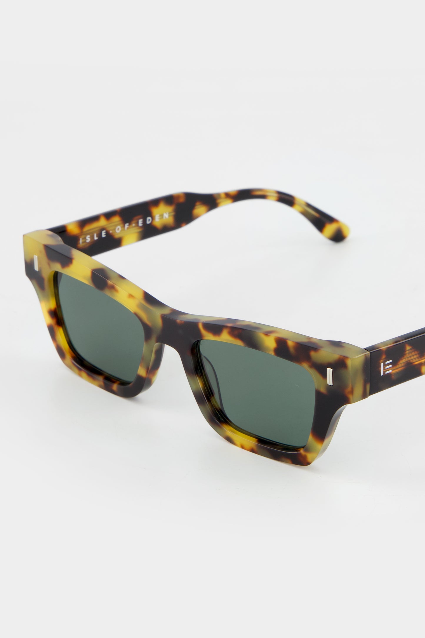 Close-up of Isle of Eden Olli tortoise sunglasses showing low-profile art-deco frame and brand lettering
