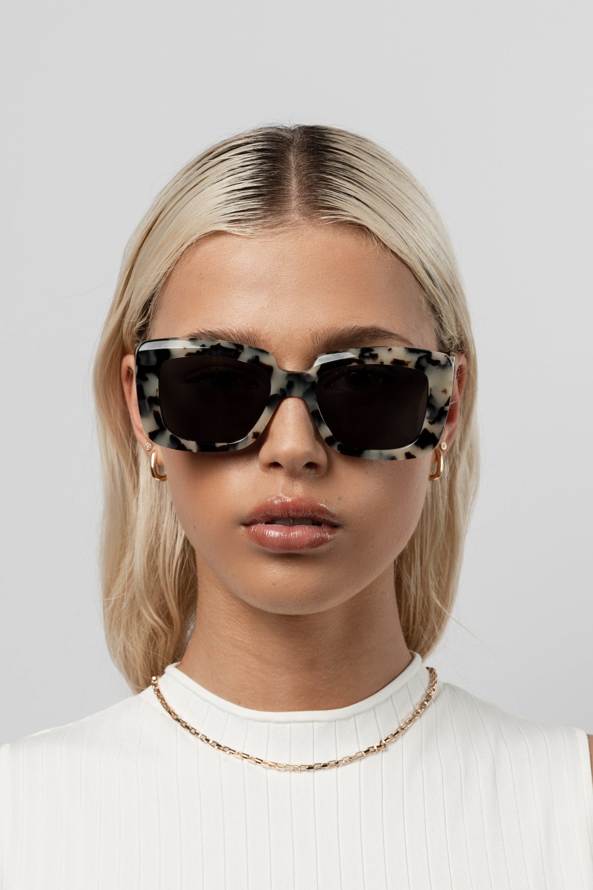 Female model wearing Isle of Eden Pia white tortoise sunglasses, close front-facing portrait