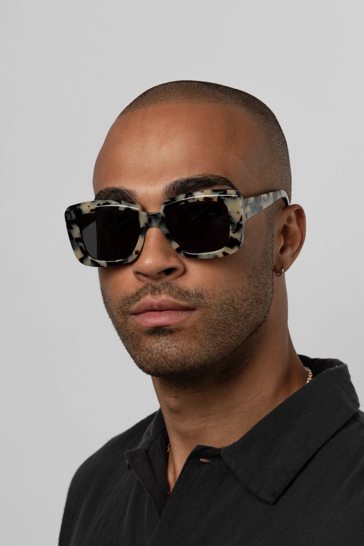 Male model wearing Isle of Eden Pia white tortoise sunglasses, front-facing portrait looking directly at the camera