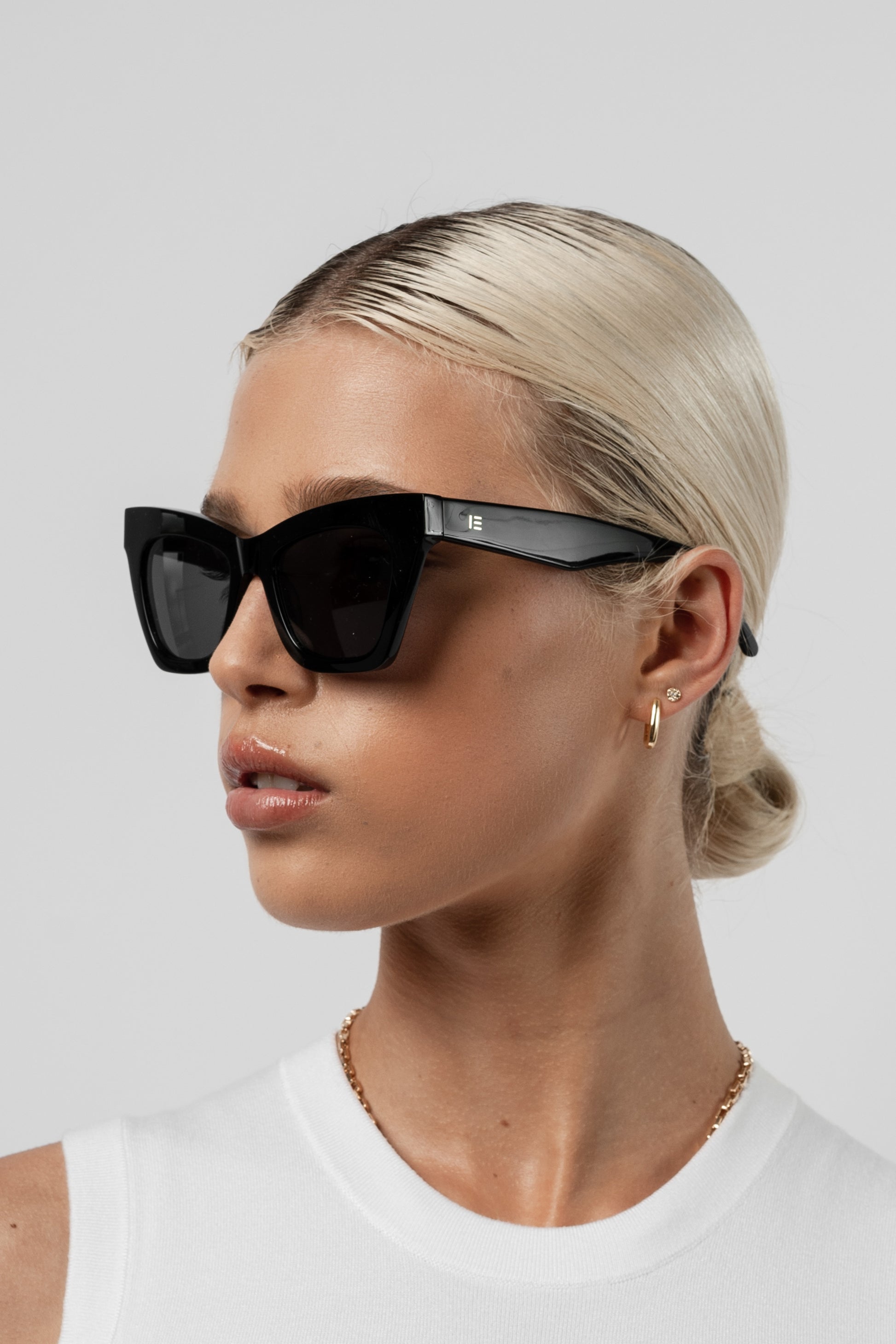 Woman wearing Isle of Eden Sienna black sunglasses, side profile portrait looking away