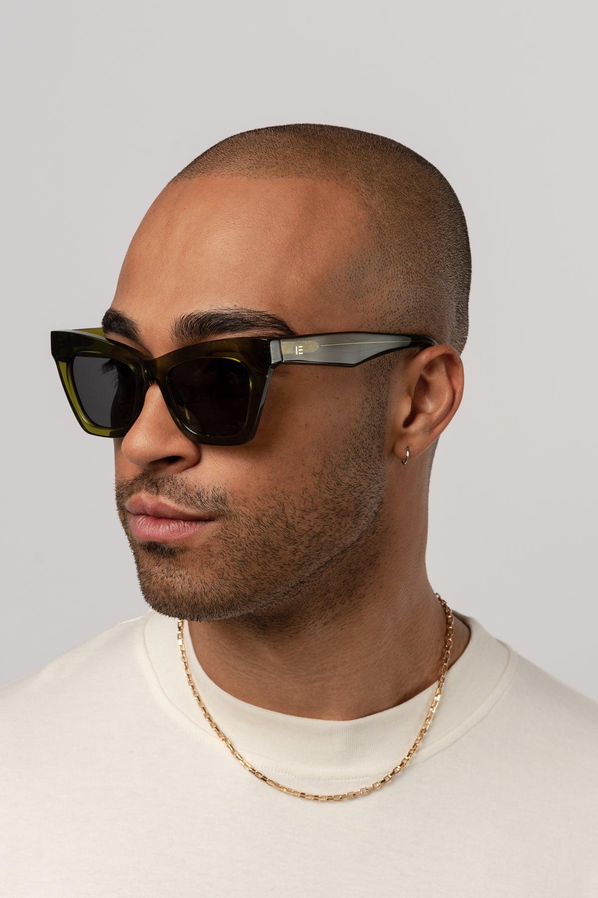 Man wearing Isle of Eden Sienna bottle green sunglasses, angled portrait