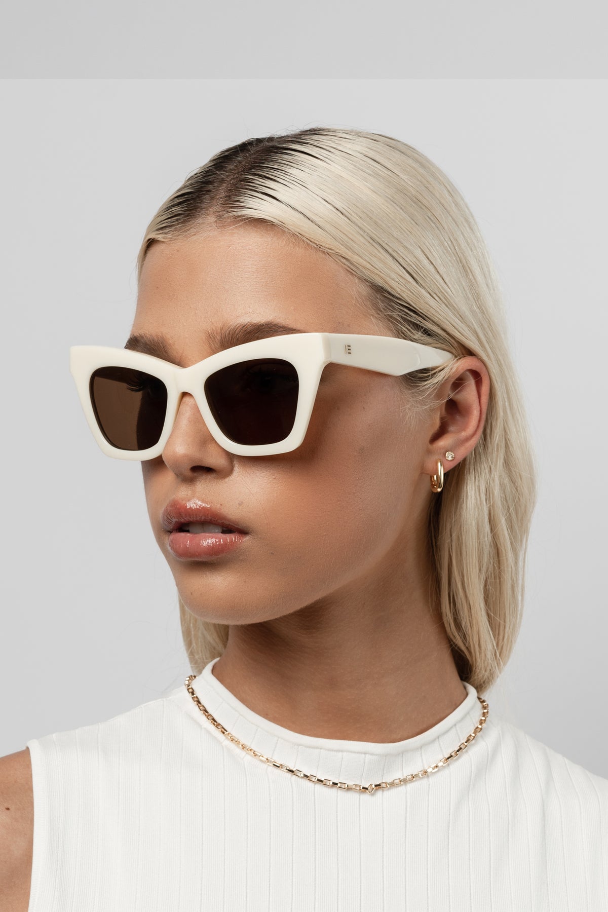 Woman wearing Isle of Eden Sienna ivory sunglasses, angled portrait looking away