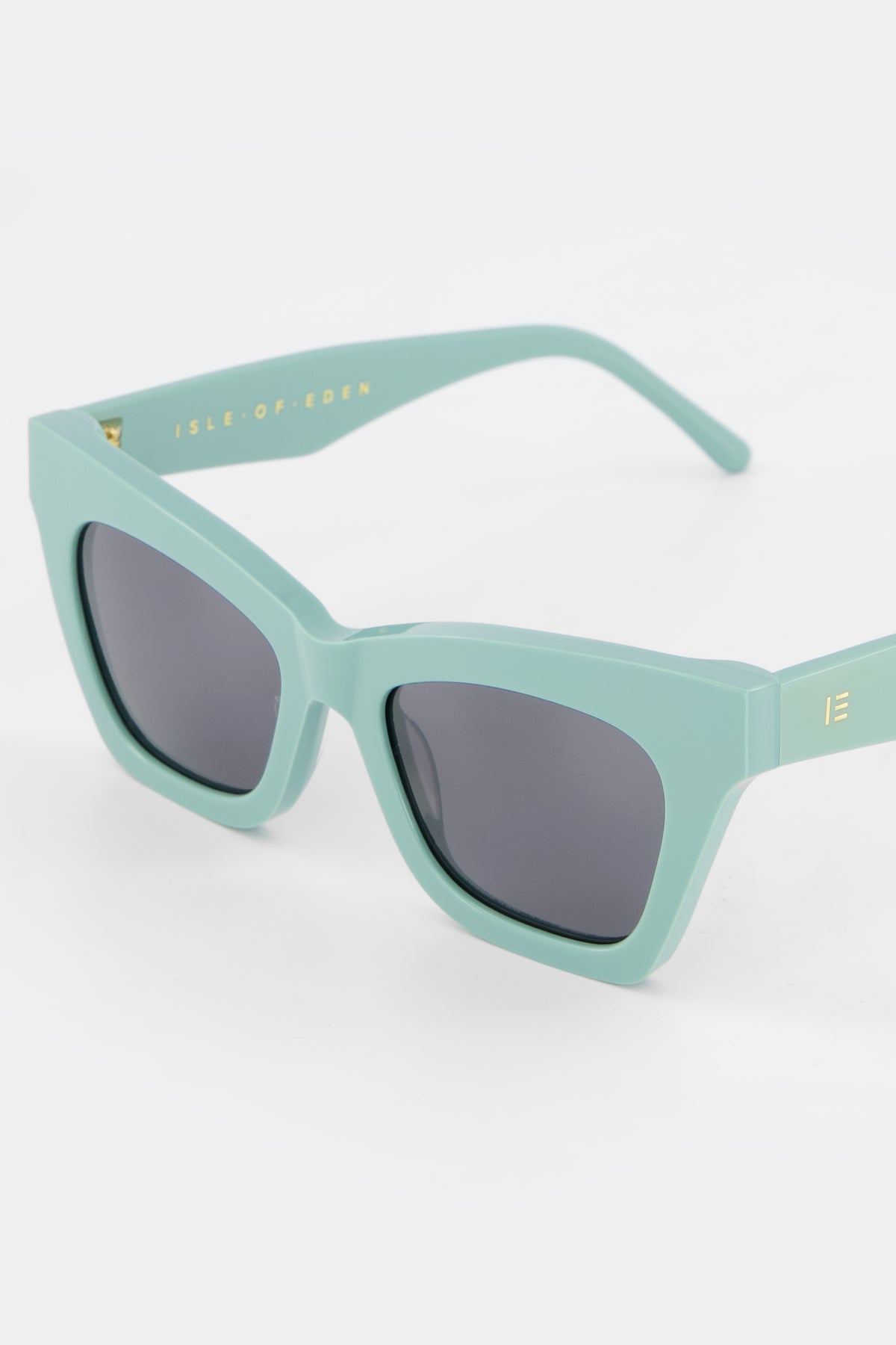 Close-up of Isle of Eden Sienna mint sunglasses showing angular cat-eye frame and brand lettering