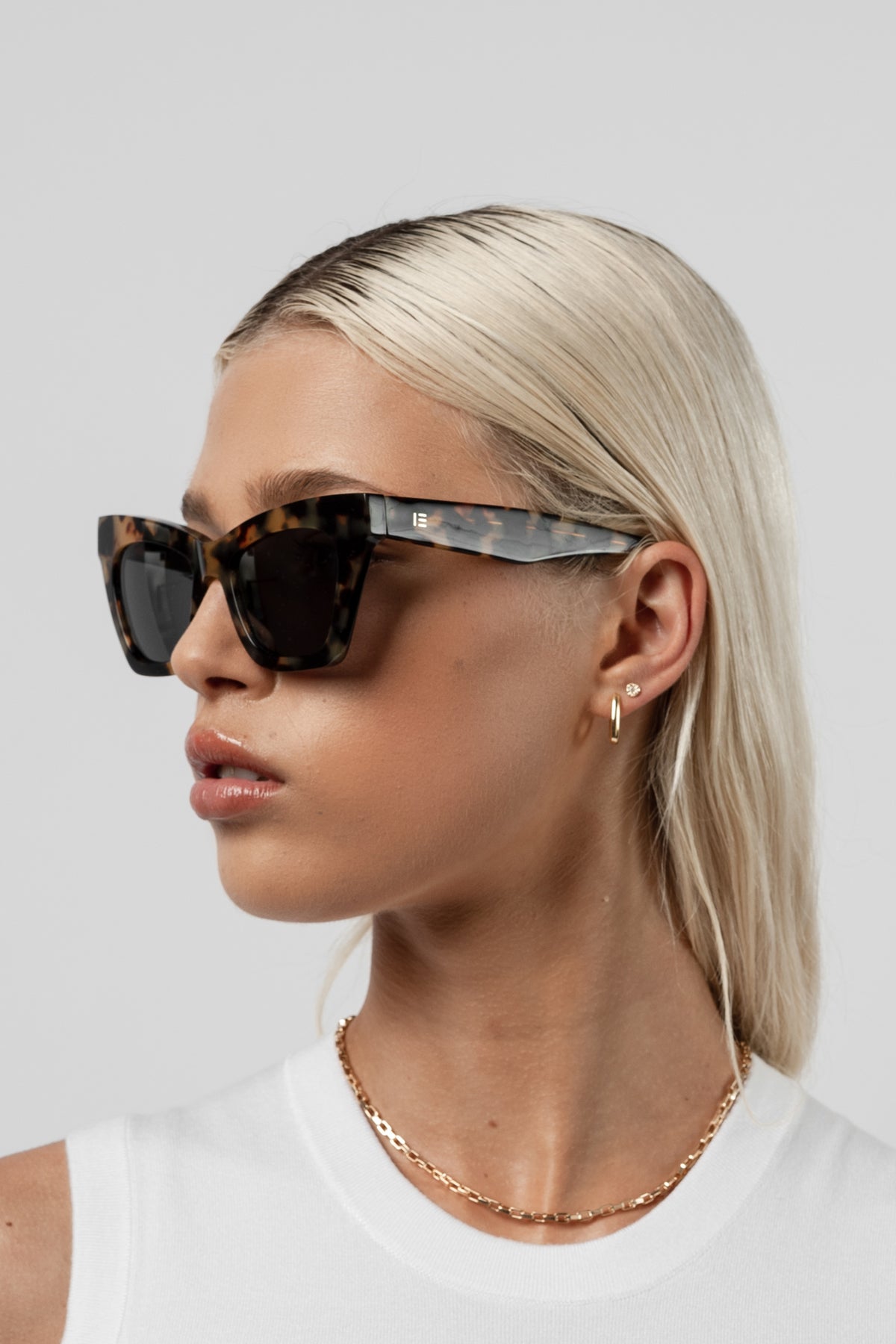 Woman wearing Isle of Eden Sienna tortoise sunglasses, angled portrait looking away