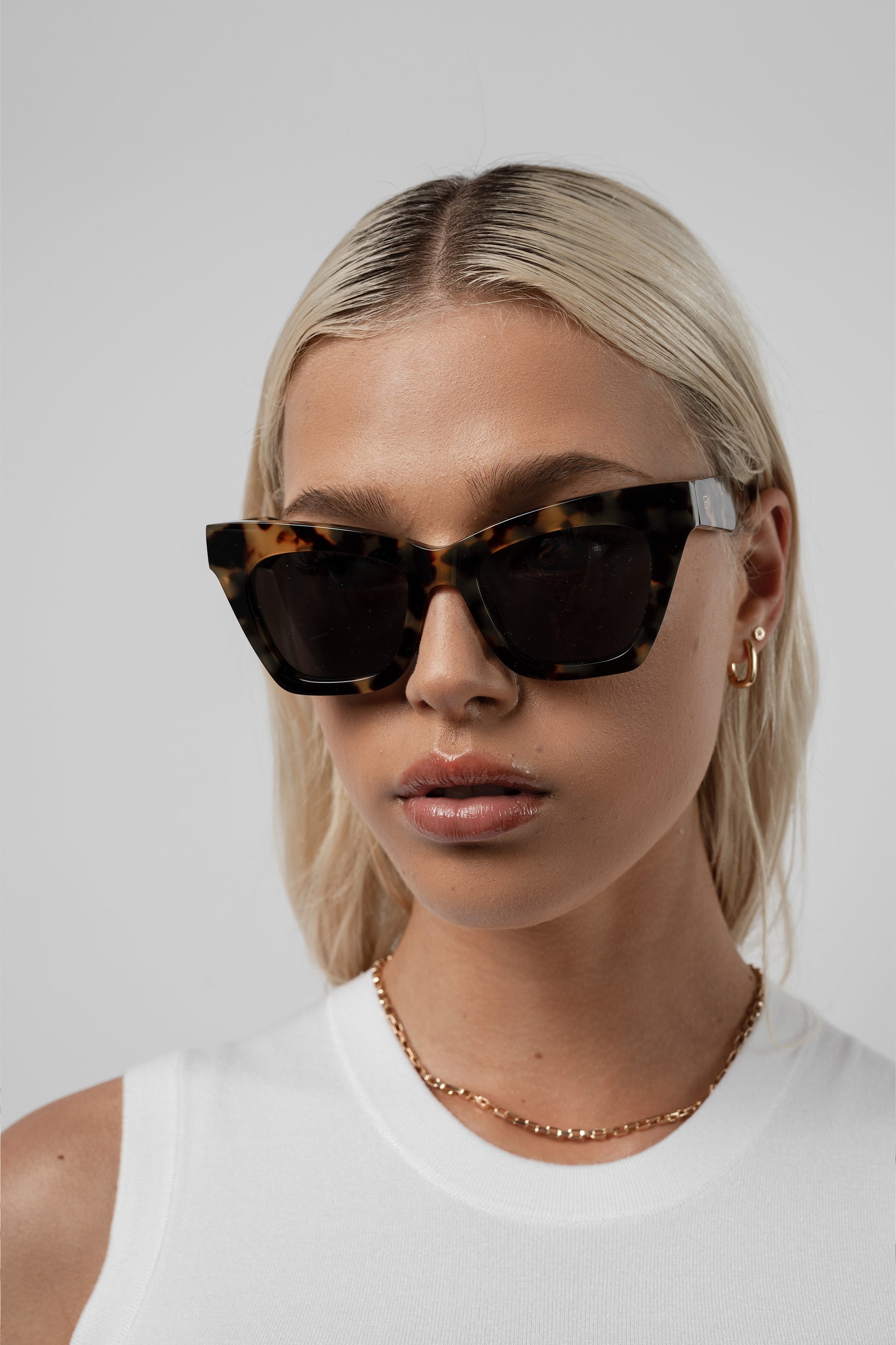 Woman wearing Isle of Eden Sienna tortoise sunglasses, front-facing portrait looking directly at the camera