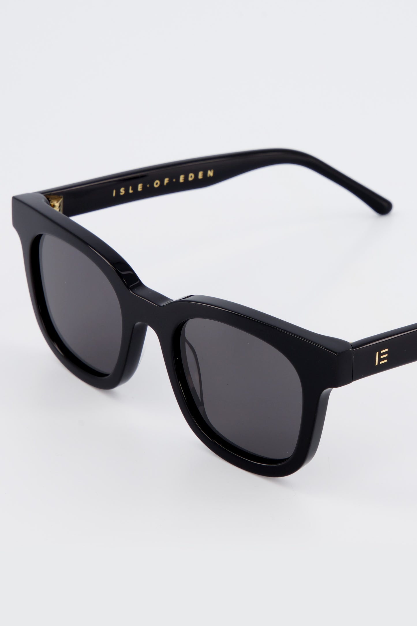 Close-up of Isle of Eden Eugene black sunglasses showing flat brow frame and brand lettering