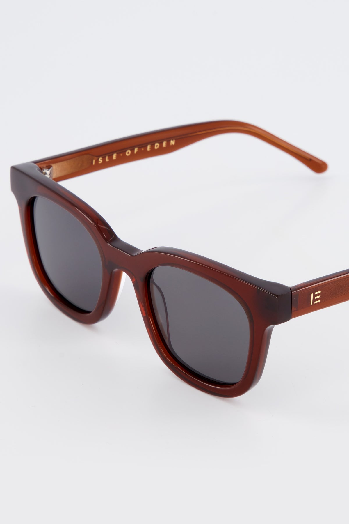 Close-up of Isle of Eden Eugene brown sunglasses showing flat brow frame and brand lettering