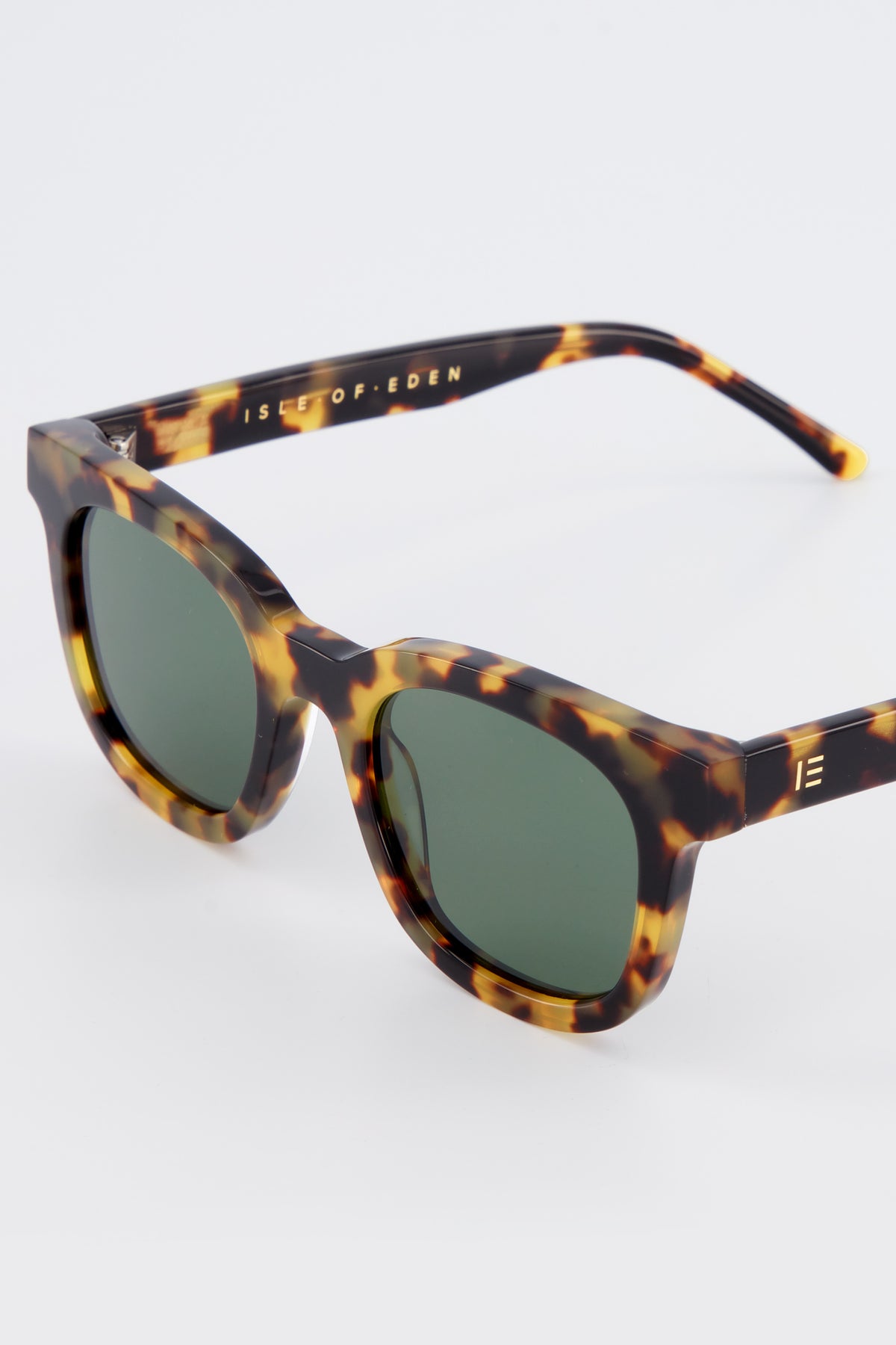 Close-up of Isle of Eden Eugene tortoise sunglasses showing flat brow frame and brand lettering