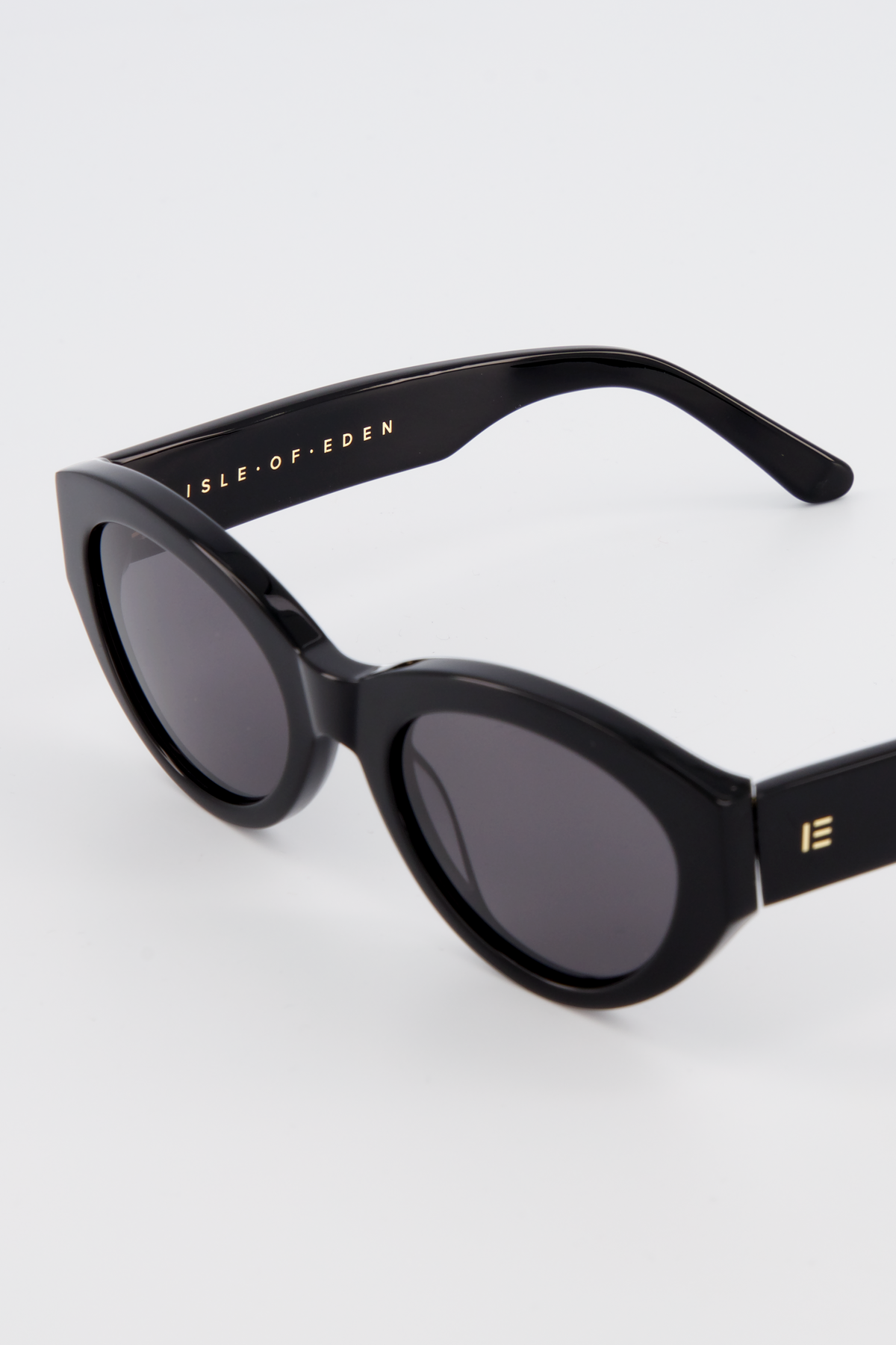 Close-up of Isle of Eden Felina black sunglasses showing cat-eye frame and brand lettering