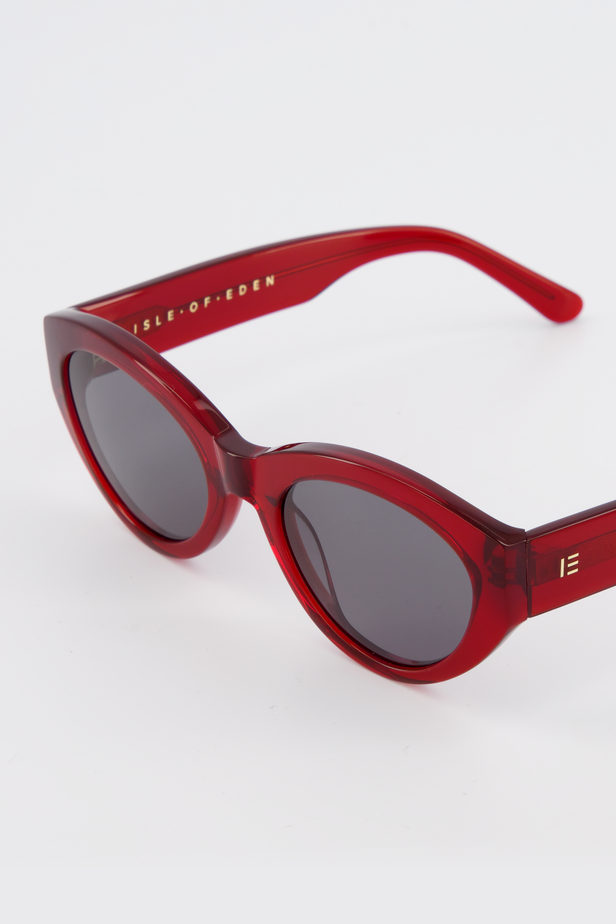 Close-up of Isle of Eden Felina red sunglasses showing cat-eye frame and brand lettering
