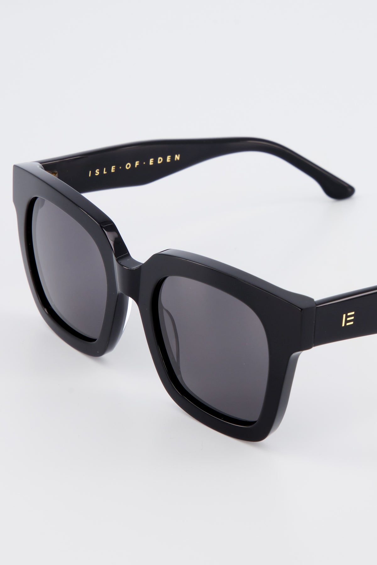 Close-up of Isle of Eden Maleika black sunglasses showing oversized frame and brand lettering