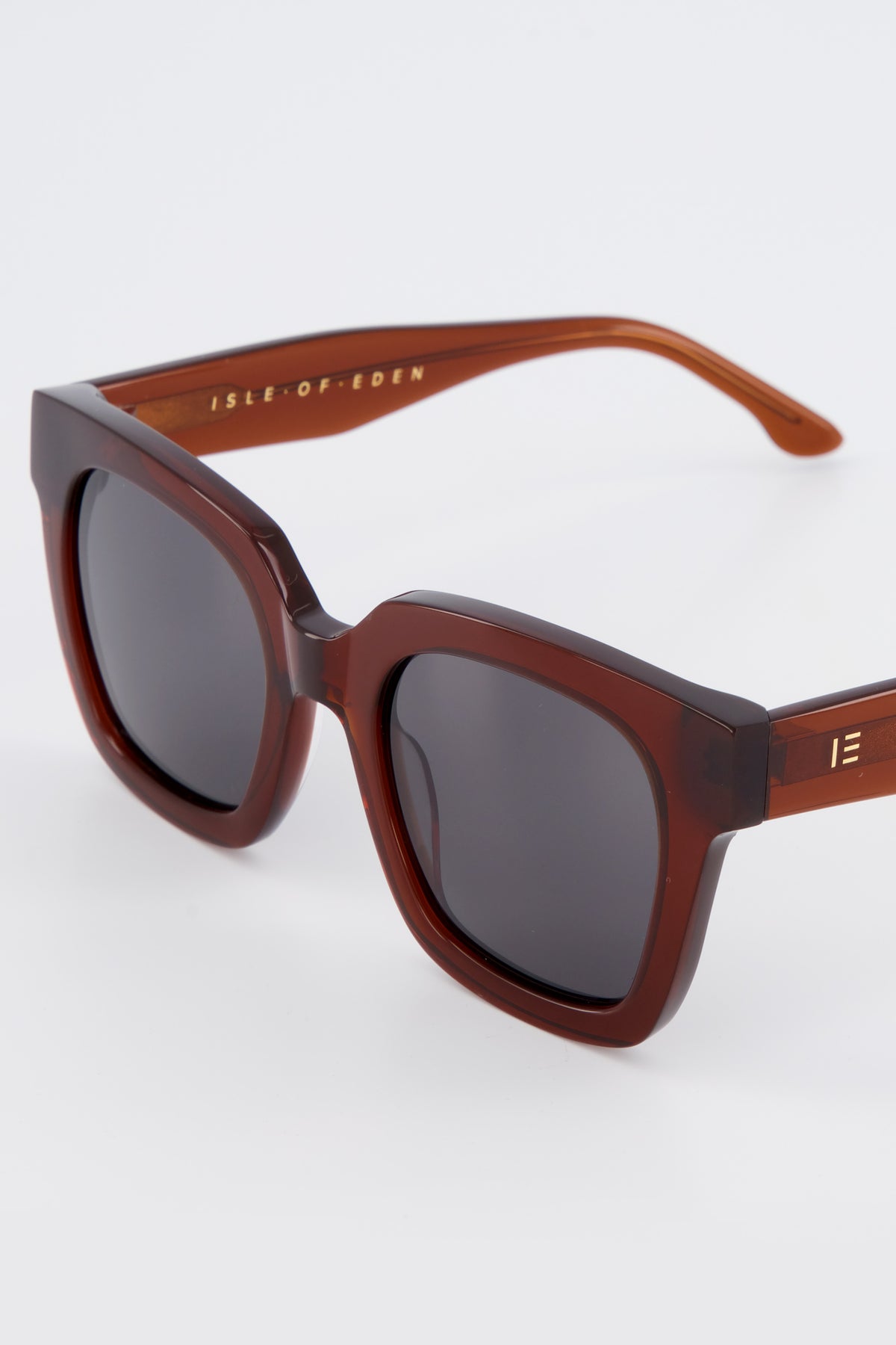 Close-up of Isle of Eden Maleika brown sunglasses showing oversized frame and brand lettering