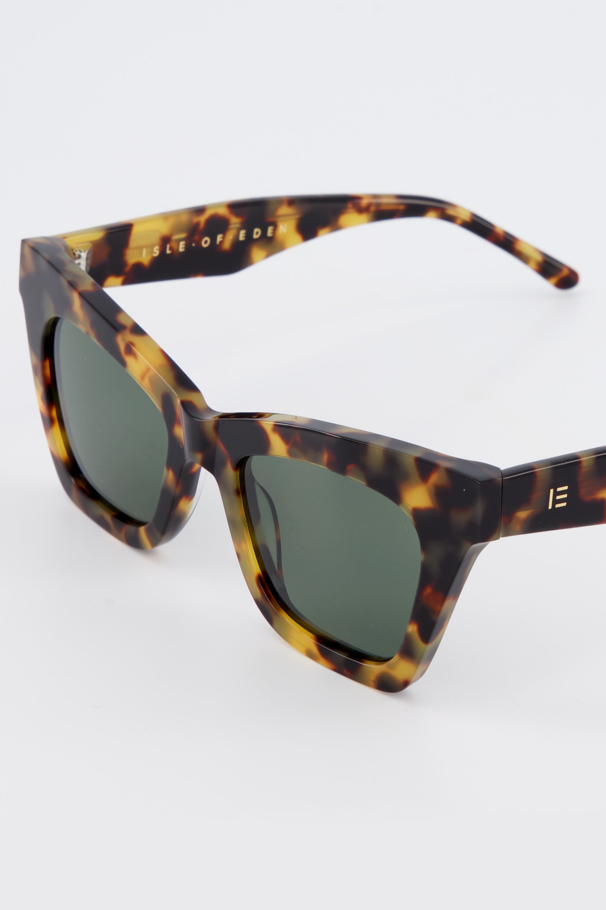 Close-up of Isle of Eden Sienna tortoise sunglasses showing angular cat-eye frame and brand lettering